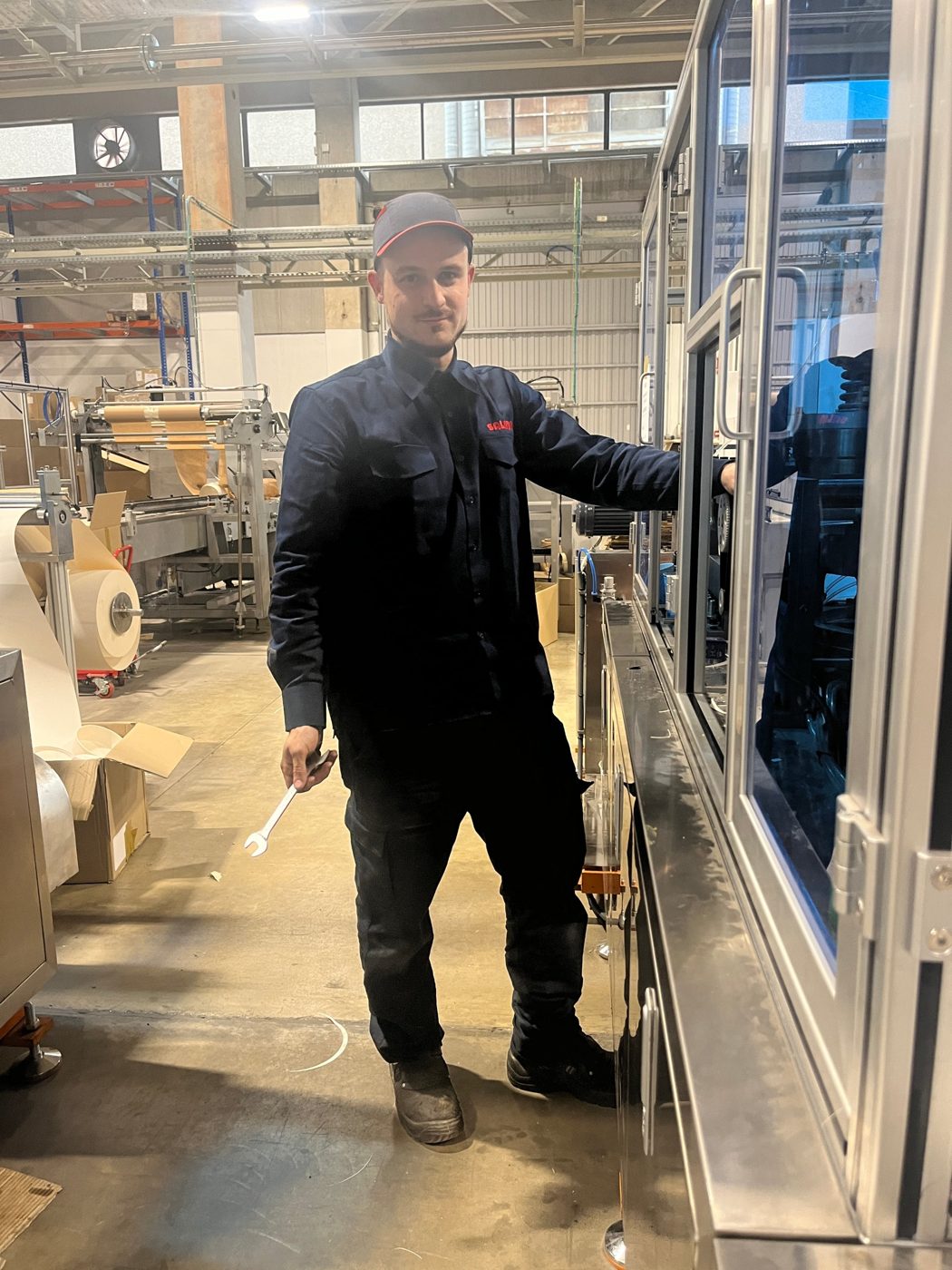 Arnau junto a la embolsadora en la planta