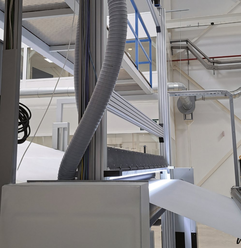 Línea de producción de Salma: manguera de aire, barra de soplado y lámina de tejido saliendo de la máquina